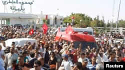 Protesters escort the body of assassinated Tunisian opposition politician Muhammad Brahmi in Tunis on July 25.