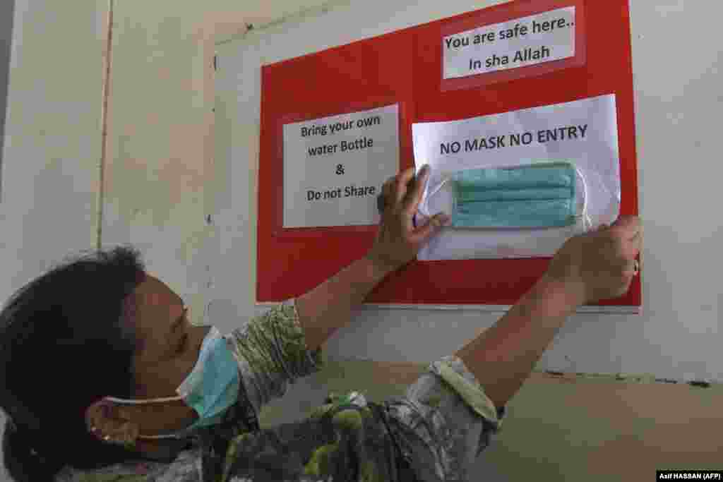 A teacher puts up a sign in a government school in Karachi following the announcement that educational institutions would reopen, starting from September 15, after nearly six months under lockdown.