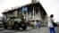 A woman takes a picture of an armoured vehicle left as a monument on Kyiv's Independence Square, known as the "Maidan."