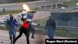 Сторонники бывшего президента ЮАР Джейкоба Зумы перекрыли автостраду горящими шинами во время акции протеста, ЮАР, 9 июля 2021 года