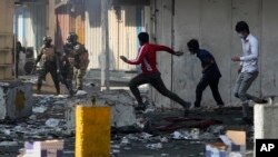 Iraqi security forces try to disperse anti-government protesters in downtown, Baghdad, Iraq, Tuesday, Nov. 12, 2019. (AP Photo/Hadi Mizban)