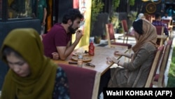 In this picture taken on August 5, 2019, a couple enjoys their meal in a cafe in Kabul, Afghanistan.
