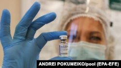 Një punonjëse shëndetësore mban në dorë vaksinën ruse kundër koronavirusit Sputnik V.