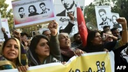Pakistani rights activists hold images of bloggers who have disappeared, during a protest in the eastern city of Lahore on January 12.