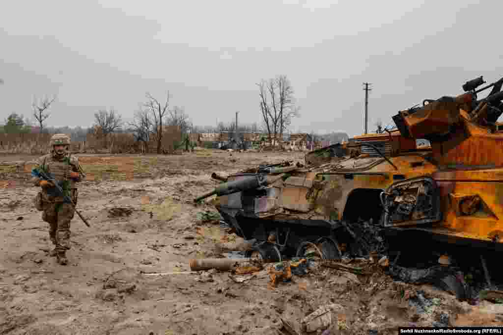 Українські військові 10-ї окремої гірсько-штурмової бригади «Едельвейс» оглядають знищений російський бронетранспортер БТР-82 у селі Тетерівське поблизу лінії фронту, 31 березня 2022 року