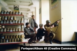 Soldiers and civilians take cover inside a shop in Timisoara.