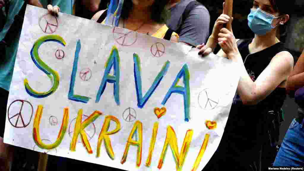 A demonstrator holds a sign that reads &quot;Glory to Ukraine&quot; while protesting in Buenos Aires on February 25.