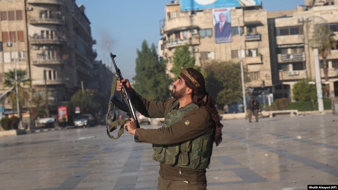 A Syrian opposition fighter shoots in the air in downtown Aleppo on November 30. 