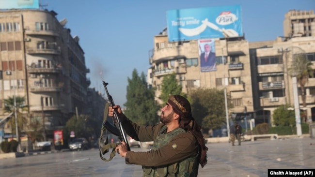 Syria - A Syrian opposition fighter shoots in the air in downtown Aleppo, November 30, 2024.