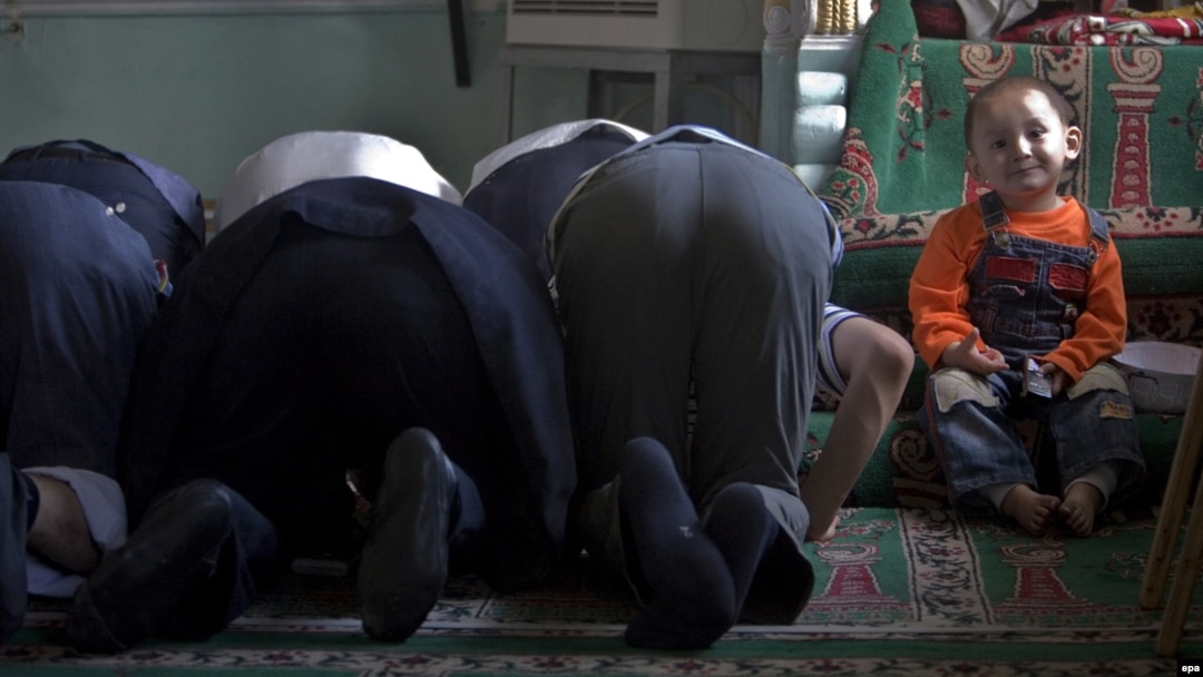 Uiguri la rugăciune într-o moschee din Urumqi, China.