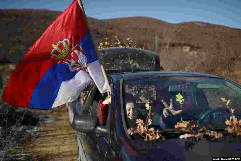 Kosovar Serbs flash victory signs and carry oak branches to celebrate Orthodox Christmas eve in the town of Gracanica on January 6. It is a regional tradition to collect dried wood on this day. Locals will leave it outdoors overnight as part of Christmas celebrations to bring luck for the new year. (epa-EFE/Valdrin Xhemaj)