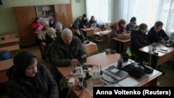 Люди заряджають свої пристрої в шкільному класі. Київ, Україна, 11 січня 2026 року
