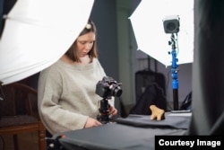 Oleksandra Ivanova documents a clay artifact in Kyiv for the virtual museum project.