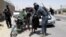 An Afghan security officer frisks a man at a checkpoint in Helmand on June 25.