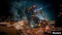 A firefighter works at the site of residential buildings heavily damaged by a Russian air strike in Sumy on September 8. An elderly couple was killed and four people were injured, including a 2-year-old girl and an 8-year-old boy.