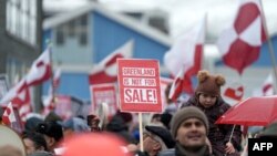 Люди махають гренландськими стягами на демонстрації проти планів президента США щодо захоплення Гренландії 17 січня 2026 року в Нууку, Гренландія