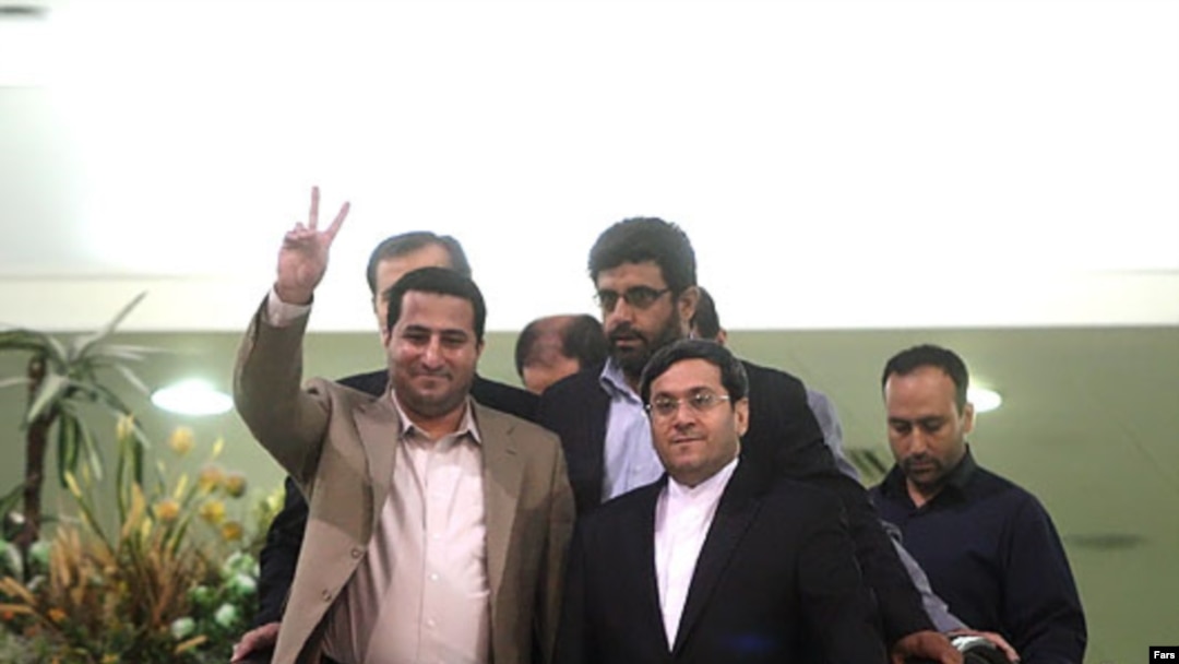 Shahram Amiri, gesturing, with Iranian authorities after his return to Tehran on July 15.