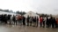 Migrants wait in line to receive food from an aid group at the Vucjak refugee camp near the Bosnia-Croatia border.