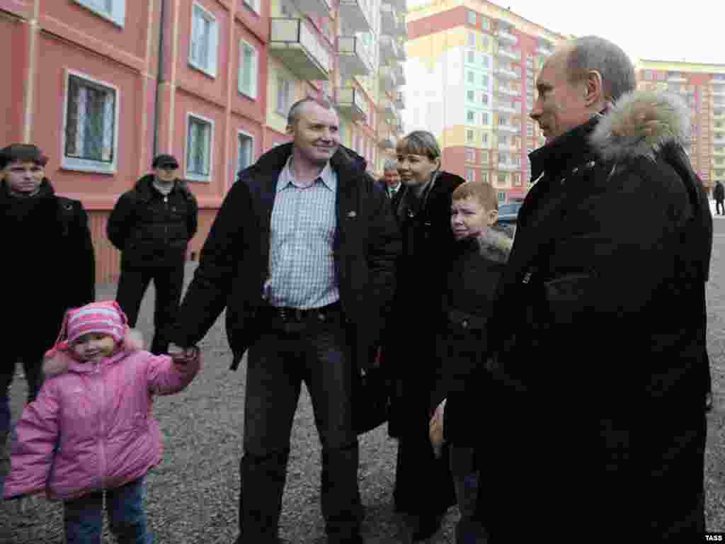 Новокузнецк. Владимир Путин (справа) и горномонтажник Евгений Денк с семьей, получивший сертификат но новую трехкомнатную квартиру