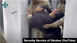 Képernyőfotó az Ukrán Biztonsági Szolgálat YouTube csatornáján közzétett videóból a kémkedéssel gyanúsított férfi őrizetbe vételéről