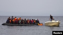 Pescarul grec Stratis Valiamos (dreapta) ajută refugiați sirieni să ajungă la malul insulei Lesbos, octombrie2015. 