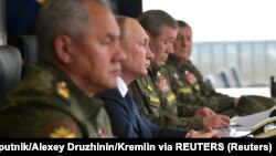 Рускиот претседател Владимир Путин (во средината), министерот за одбрана Сергеј Шојгу (лево) и началникот на Генералштабот на вооружените сили на Русија, Валери Герасимов (десно), ги набљудуваат воените вежби во септември 2021 година.
