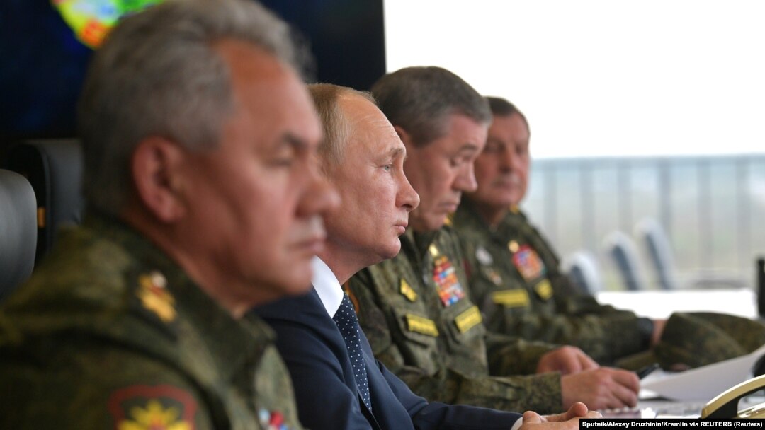 Președintele rus Vladimir Putin (centru), ministrul Apărării Serghei Șoigu (stânga) și șeful Statului Major General al forțelor armate ale Rusiei, Valeri Gherasimov (dreapta), observă exercițiile militare din septembrie 2021.