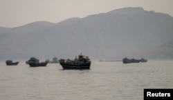 Vessels are anchored in the Strait of Hormuz, as seen from Musandam, Oman, on June 19. Iran has opened the strait as part of the agreement with the United States.