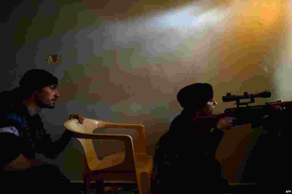 A Syrian female rebel monitors the movement of government forces in the Sheikh Maqsud district of the northern city of Aleppo. (AFP/Dimitar Dilkoff)