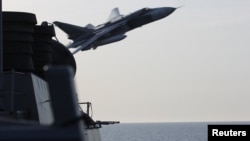 A U.S. Navy picture shows a Russian Sukhoi Su-24 attack aircraft making a very low pass close to the U.S. guided missile destroyer USS Donald Cook in the Baltic Sea on April 12.