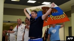 Russian soccer-fan leader Aleksandr Shprygin holds a flag as he leaves Moscow with others fans for Euro 2016.