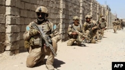 Afghan National Army commandos take positions during a military operation in 2016.