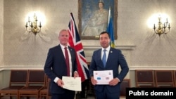 Қазақстан мен Ұлыбританияның қорғаныс министрлік өкілдері әскери ынтымақтастықты жалғастыру туралы құжатқа қол қойып тұр. Лондон, 5-6 маусым 2025 жыл.