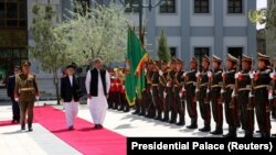 Afghan President Ashraf Ghani and Pakistani Prime Minister Shahid Khaqan Abbasi inspect the honor guard at the presidential palace in Kabul on April 6.