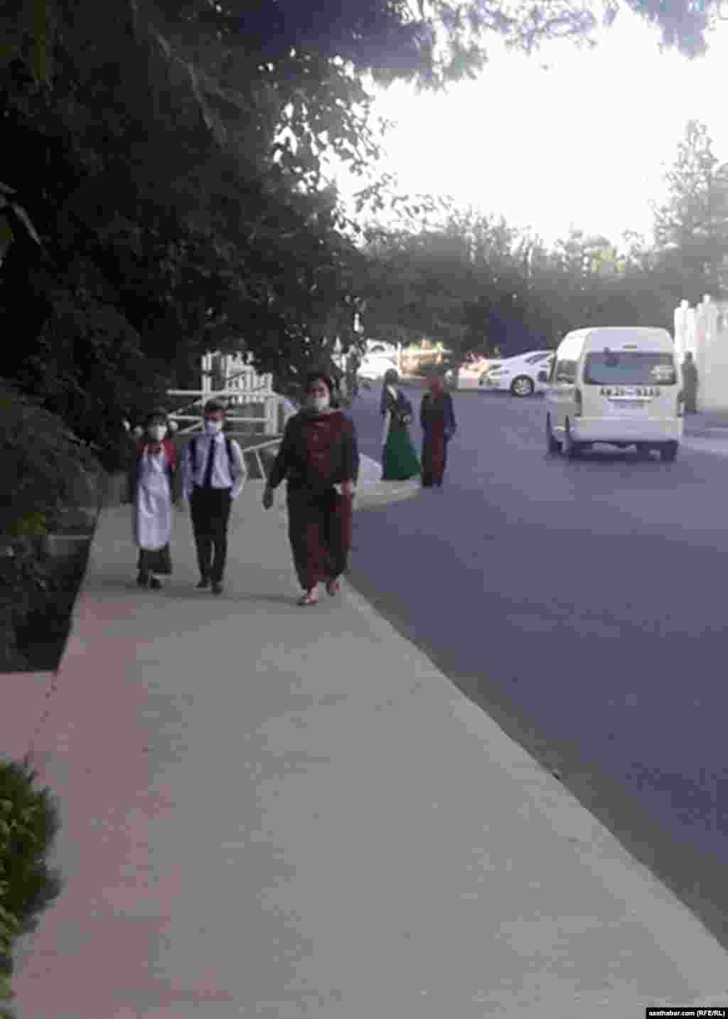 Pandeniýa döwründe başlanan täze okuw ýylynda çagasyny mekdebe alyp barýan ene. Hemmeler maska geýmeli edildi. Sentýabr, 2020