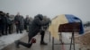 A man mourns next to a coffin containing the body of a Ukrainian servicemen who was killed fighting Russian troops, at a funeral ceremony in Kharkiv on February 5. 