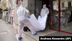 Forensic workers carry the body of Gholamreza Mansuri from a hotel in downtown Bucharest on June 19, 2020.