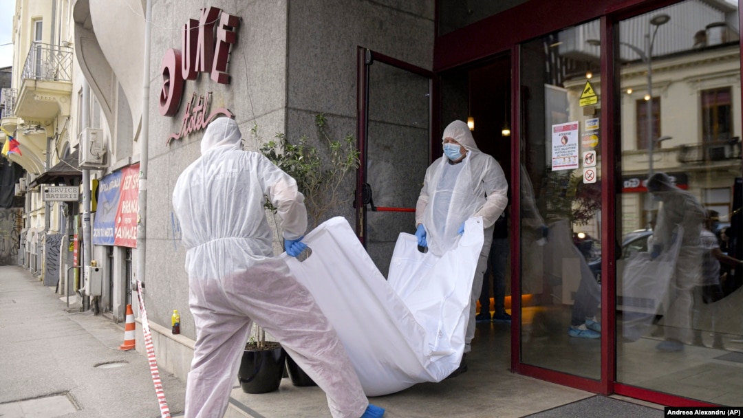 Forensic workers carry the body of Gholamreza Mansuri from the Duke Hotel in downtown Bucharest.