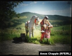 Painted figures of a traditionally dressed couple outside a souvenir store in the Carpathian Mountains.