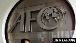 (FILES) This file photo taken on October 10, 2001 shows a worker putting the finishing touches to the new logo of the Asian Football Confederation (AFC) at their headquarters in Kuala Lumpur.