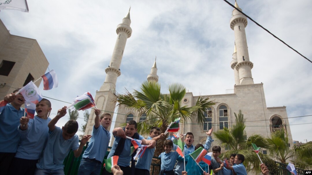 Residents of the Arab Israeli town of Abu Ghosh wave the Chechen flag during the dedication ceremony for the Akhmad Kadyrov Mosque in 2013. The building, which dominates the skyline, was funded by Akhmad's son and current Chechen leader Ramzan Kadyrov. 