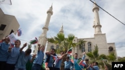 Residents of the Arab Israeli town of Abu Ghosh wave the Chechen flag during the dedication ceremony for the Akhmad Kadyrov Mosque in 2013. The building, which dominates the skyline, was funded by Akhmad's son and current Chechen leader Ramzan Kadyrov. 