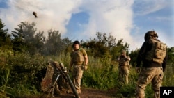 Ukrainian soldiers fire mortars toward Russian positions at the front line near Bakhmut in the Donetsk region on June 30