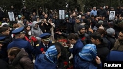 People attend the funeral of crew members of Azerbaijan Airlines flight J2-8243 that crashed near the Kazakh city of Aqtau, in Baku on December 29. 