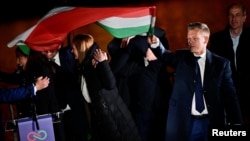 Peter Mađar, vođa opozicione stranke Tisza, sa nacionalnom zastavom nakon djelomičnih rezultata parlamentarnih izbora u Budimpešti, 12. aprila 2026.