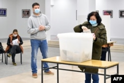 A woman casts her vote for local elections in Mostar on December 20, 2020. Mostar was the only Bosnian city that had not held local elections in 12 years. Split into Croat and Bosniak zones by the Dayton agreement, the town became a symbol of the broken politics that has haunted the Balkan state ever since.