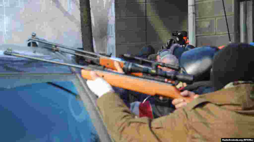 Protesters aim weapons in Kyiv&#39;s government district on February 18.