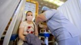 O tânără din R. Moldova își administrează vaccinul anti-COVID-19 în cadrul unui marafon la Palatul Republicii, iunie, 2021