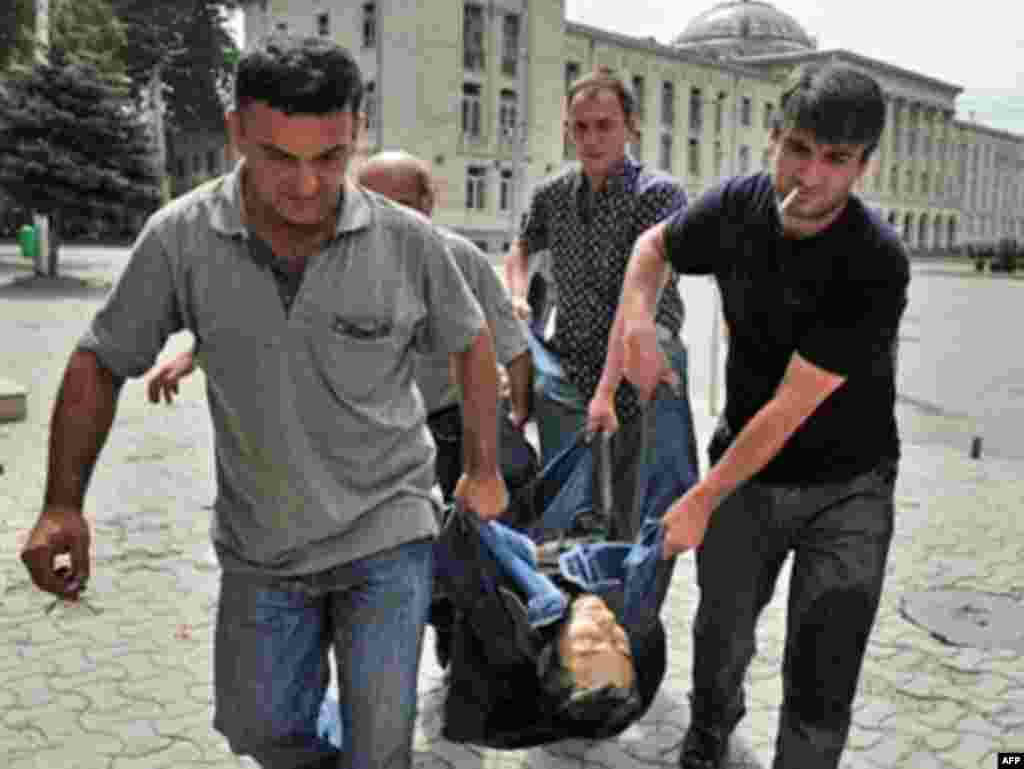 GEORGIA, GORI : Georgian men carry the body of a man killed by a shell on Joseph Stalin squere in the town of Gori on August 12, 2008. The central square of the Georgian city of Gori was bombed, causing casualties, and university buildings there are burning, Georgian public television reported