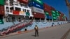 Пакистанский военный в порту Гвадар на фоне готовящегося к отплытию груженого китайского контейнеровоза 